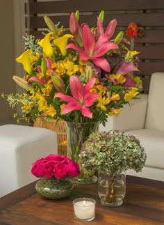 a vase filled with flowers sitting on top of a wooden table next to a candle