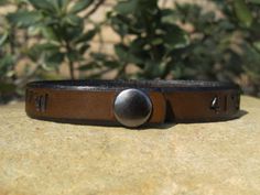 This custom infinity BRACELET is hand tooled and stained with a lovely antique medium brown that seems to glow in the sunlight, or another stain of choice. This bracelet is 1/2 inch wide and has a very durable metal snap holding it together. In the center of the bracelet is an infinity symbol, please note with your order if you desire it to be placed in another area on the cuff. It can be made with a name and/or date, coordinates, special text (the Character amount is below) or whatever you wish Adjustable Vintage Brown Bracelets As Gift, Adjustable Vintage Brown Bracelet As Gift, Adjustable Vintage Brown Bracelet For Gift, Distressed Brown Leather Bracelet Gift, Rustic Distressed Brown Bracelet For Gift, Adjustable Vintage Brown Jewelry Gift, Brown Leather Bracelet With Engraving Option, Adjustable Brown Wristband For Father's Day, Adjustable Brown Engraved Cuff Bracelet