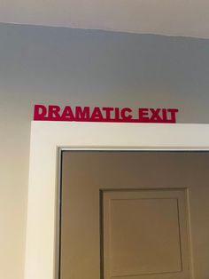 the sign above the door says dramatic exit and is red on white with black lettering