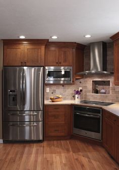 a kitchen with stainless steel appliances and wooden cabinets