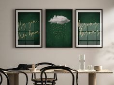 two green paintings hang on the wall above a dining room table with chairs and a black chair