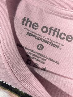 pink shirt with the office logo on it