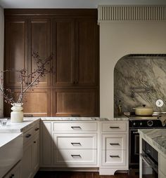 a kitchen with marble counter tops and wooden cabinets, along with an oven in the center