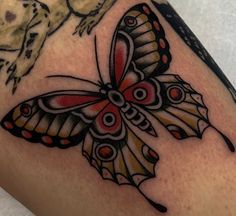 a close up of a butterfly tattoo on someone's arm