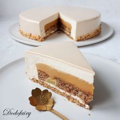 a piece of cake on a white plate with a gold flower next to the slice