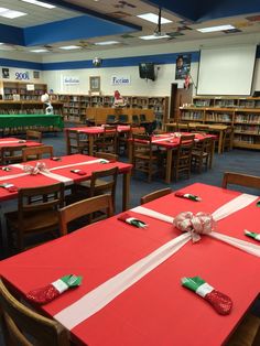 tables with red and white tablecloths are set up in the middle of a library