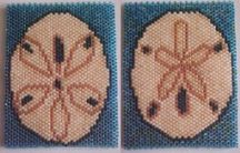 two cross stitched coasters with sand dollar signs on them, one in blue and the other in white