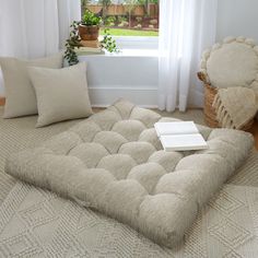 a large futon mattress sitting on top of a rug in front of a window