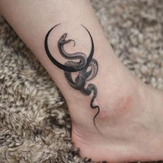 a tattoo on the foot of a person with a snake in it's claws