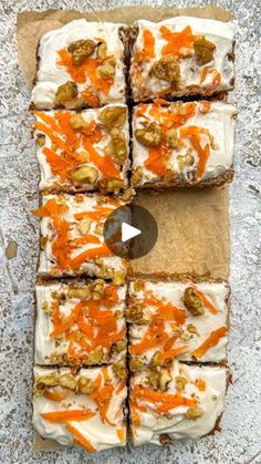 carrot cake with cream cheese frosting and walnuts on top, cut into squares