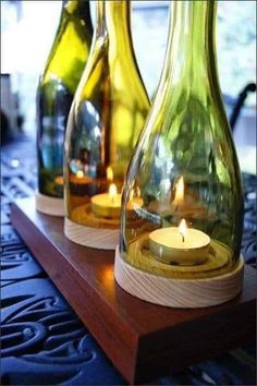 three vases with candles in them sitting on a table