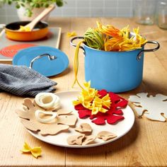 a blue pot filled with flowers sitting on top of a table next to other items