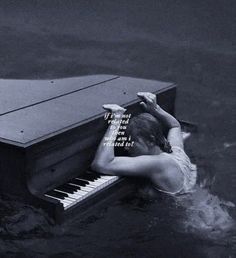 a woman in the water with her head on an old piano that has been partially submerged