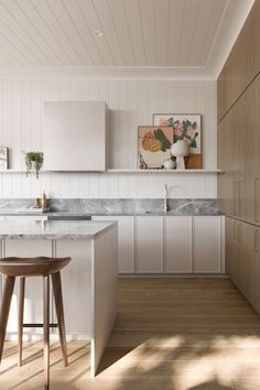 a kitchen with two stools next to an island