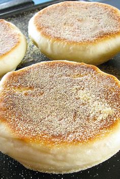 three pancakes sitting on top of a pan covered in powdered sugar