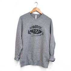 Stay warm in style with the Frickin Freezin unisex pullover in athletic grey. This cozy and trendy top is perfect for chilly days. Its "frickin freezin" design adds a playful touch, while the unisex fit makes it versatile and comfortable. Stay fashionably warm this season! Unisex SizingBody Length: S-27 3/4", M-29", L-30", XL-31", 2XL-32"CHEST WIDTH: S-19.5", M-20.5", L-21.5", XL-22 3/4", 2XL-24" A Montana Scene Original Design. Printed in Montana. All designs are property of The Montana Scene. Kids Onesies, Kids Beanies, Trendy Top, Sock Gifts, Kids Hats, Kid Tees, Trendy Tops, Womens Tank, Stay Warm