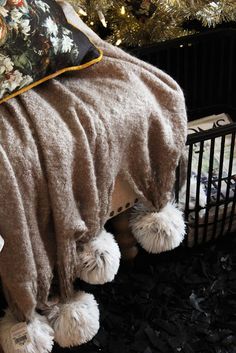 a blanket draped over a crib in front of a christmas tree