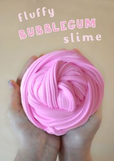 a person holding a ball of pink slime in their hands with the words fluffy bubblegum slime on it