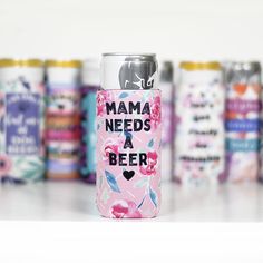 a pink can with the words mama needs a beer printed on it next to other cans