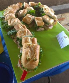 several sandwiches are arranged on a green table