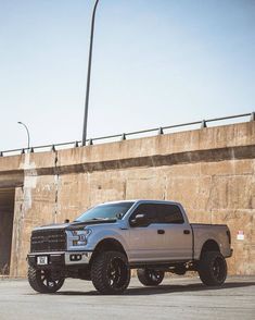 a silver truck parked in front of a concrete wall