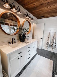 a bathroom with two sinks and mirrors in it