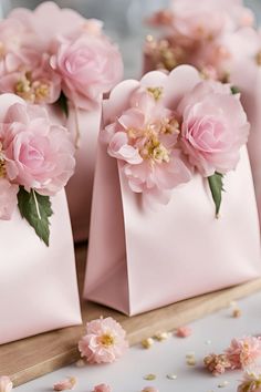 small pink bags with flowers in them on a table