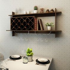 a dining room table with plates and wine glasses on it, next to a book shelf