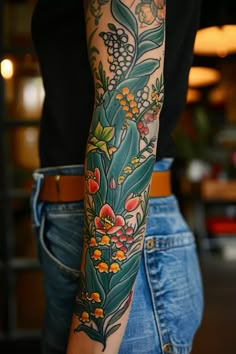 a woman's arm with flowers and leaves tattooed on the side of her body