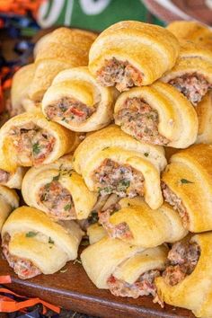 a pile of sausage rolls sitting on top of a wooden tray