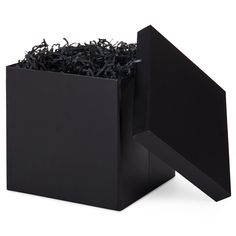 a black box filled with shredded paper on top of a white surface