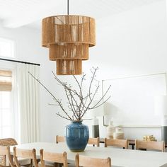 a dining room table with chairs and a large blue vase on top of the table