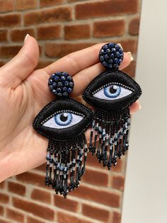 Unique Evil eye embroidered earrings made of czech shining beads and crystals. Back side made of leather. Only 1 pair.  100% Handmade.  Knitted by hand.  No machines or additional tools are used. 1 pair of earrings is made in 1 week . Earrings are very light not heavy. Great gift idea. I can make these earrings in any other color, just let me know.   Length  11 cm or 4.3 Inches Beaded jewelry requires careful and loving care.  Avoid contact with hairspray, perfume, water, bleaches & lotions. Avo Earrings With Eyes, Luxury Handmade Beaded Earrings, Luxury Beaded Earrings As Gift, Luxury Beaded Earrings For Gift, Luxury Traditional Beaded Earrings For Gift, Luxury Traditional Beaded Earrings As Gift, Handmade Luxury Jewelry, Embroider Earrings, Beads Clothes