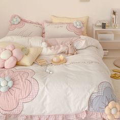 there is a bed with pink and white comforter on the floor in this room