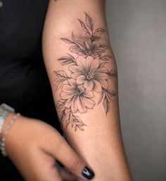 a woman's arm with a flower tattoo on it