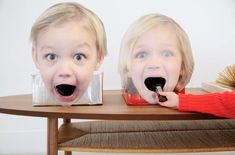 two children with their mouths open sitting at a table