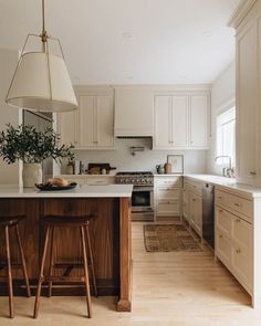 a kitchen with white cabinets and wooden stools