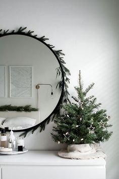 a white dresser with a mirror and christmas tree