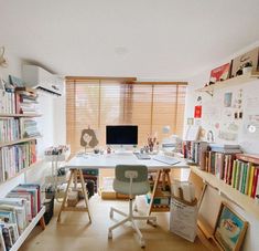 a home office with bookshelves, desk and computer on top of the desk