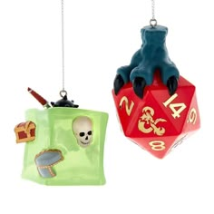 two ornaments that are shaped like dices with skulls and bones hanging from strings on white background