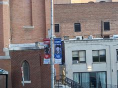 there is a street sign on the corner with buildings in the background