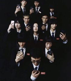 a group of young men in suits and ties holding cell phones