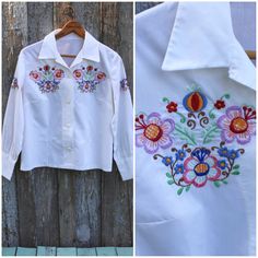 "Vintage 1960's or 1950's blouse. Hungarian made (no tag but I bought with another shirt that was). Has beautiful embroidery and carved mother of shell buttons. Good condition - one VERY light stain on front, it was so light I couldn't get it to show up in a picture. / / / / / / MEASUREMENTS: / / / / / / (all were taken while laying flat - double where necessary) ESTIMATED size: Medium (this is a GUESS...please use measurements!) CHEST (armpit to armpit): 20\" SHOULDER (seam to seam): 14.5\" LEN Retro Floral Embroidered Button-up Top, Retro Embroidered Button-up Top, Vintage Embroidered Collared Blouse, Vintage Collared Shirt With Floral Embroidery, Vintage Embroidered Spring Shirt, Vintage Embroidered Button-up Shirt, Retro Embroidered Collared Top, Retro Collared Embroidered Top, Vintage Multicolor Embroidery Blouse For Spring