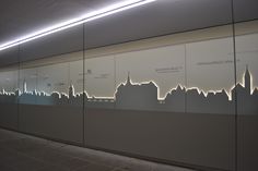 the city skyline is projected on glass in front of a wall with white lettering and lights