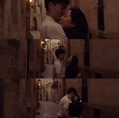 two people are kissing in an alley way