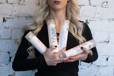 a woman holding four tubes of lipstick in her hands