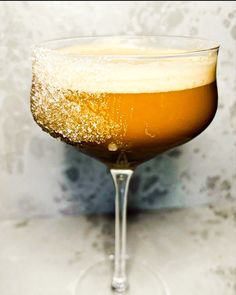 a close up of a drink in a wine glass with sugar on the rims