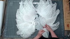 someone is working on something that looks like plastic bags with flowers attached to the sides