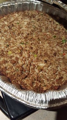 an uncooked pizza sitting on top of a pan covered in tin foil with toppings