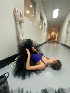 a woman is laying on the floor in a ballerinas tutu and ballet shoes